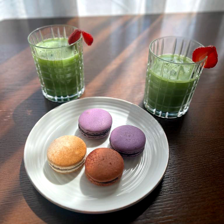 Du stikliniai matcha gėrimai su braškėmis ir desertu